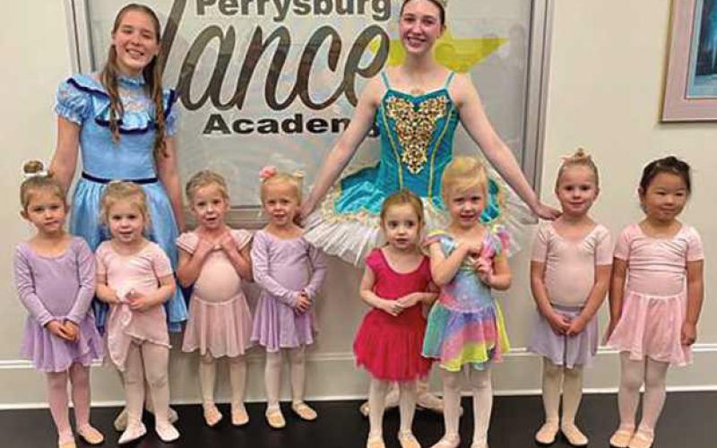Pictured are Cameryn Secrest (Clara) and Brooke Bagdonas (Dew Drop, graduating senior) introducing a group of Perrysburg Dance Academy’s youngest dancers to their characters and costumes in “The Nutcracker.”