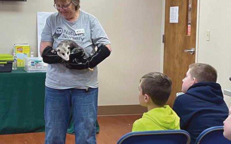 Club members Landon Knestrick and Hunter Gauld enjoy learning about the animals at Nature’s Nursery from Kim Kaseman.