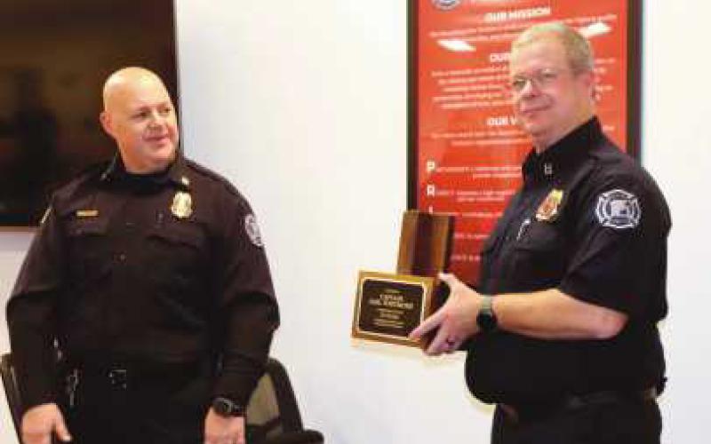 Chief McCullough, left, gives Whitmore, right, his engraved hat stand.