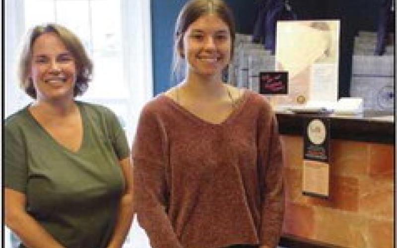 Heidi Locknane, new owner of the Salt Cave, with McKenna Encalado, a “cave host.” The reception desk features Himalayan pink salt bricks. Below is the room where clients can sit comfortably, relax and breathe in the salt.