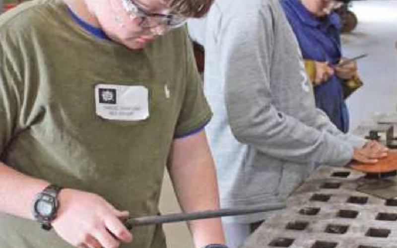 Above left Samuel Danford, foreground, and Sohan Gaddipati, Perrysburg Junior High School students, shave desktop organizers in preparation for welding. Kevin Orlowski,