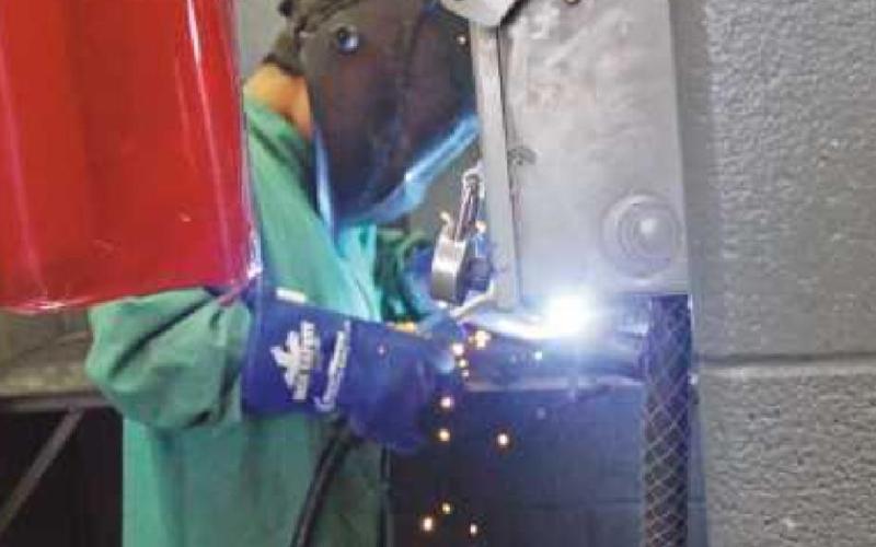 above right, a student at Hull Prairie Intermediate, works on his welding project. In addition to the desktop organizers, campers created metal spiders.