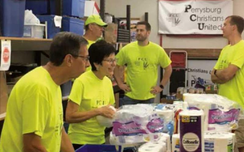 PCU volunteers wrapping toilet paper at the food pantry