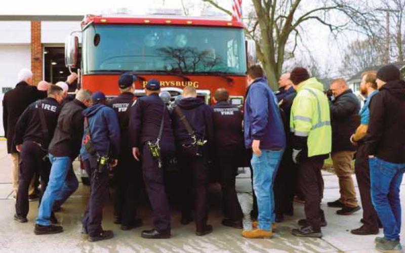 Firefighters push the fire engine into the station.
