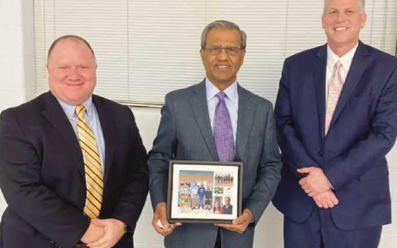 Dr. Razi Rafeeq, middle, received recognition for his work in the community. With him are at left, Eric Benington, president of the board of education, and Superintendent Tom Hosler.