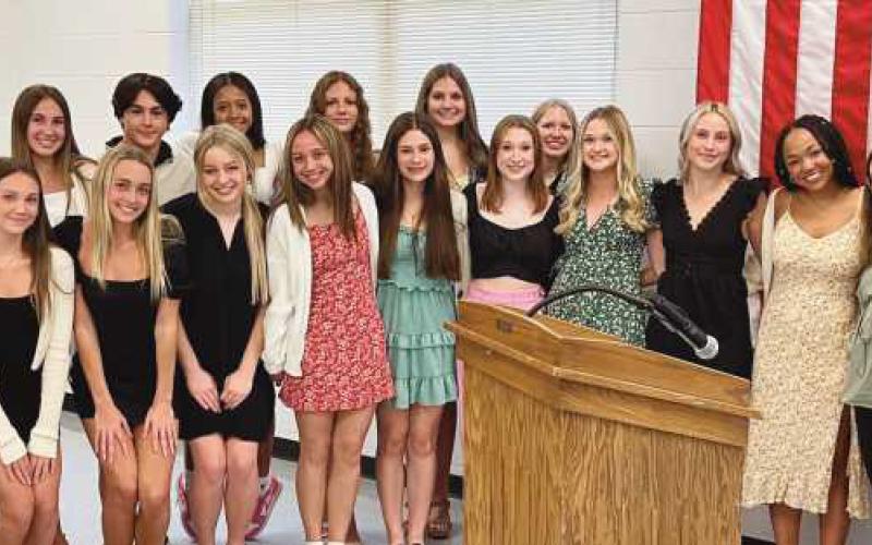 Board member Kelly Ewbank with members of the state-qualifying game day competitive cheerleading team.
