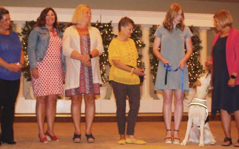 Washington Local Schools superintendent Dr. Kadee Anstadt, fourth from left, receives Granger from Ability Center volunteers Mary Miller and Karen Bade. Also trained to be Granger’s new handlers are WLS staff, from left, Brittani Paszko, director of equity and inclusion; Lori Berryman, director of human resources; and Kristie Martin, assistant superintendent.