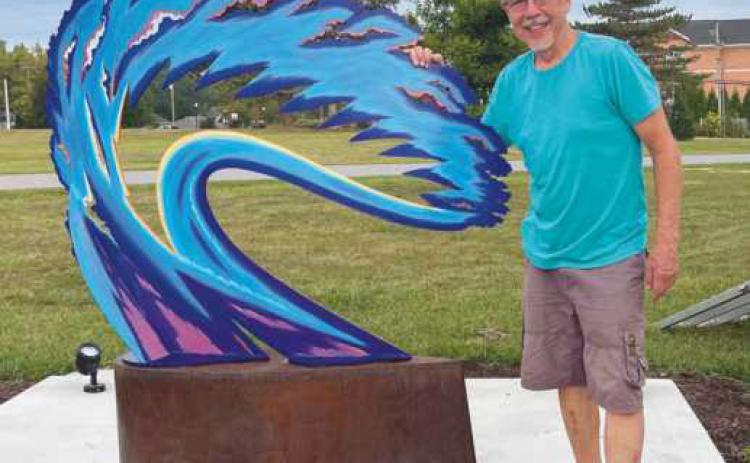 Artist Robert Garcia with his sculpture Burning Bush.