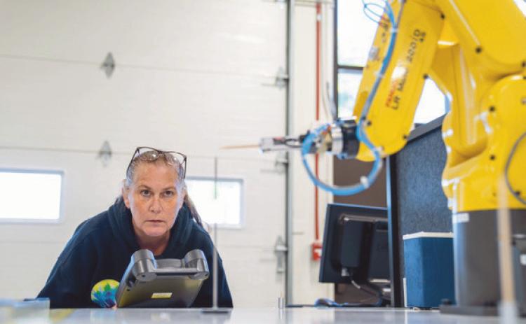 Owens student, Sandra Glosch, uses one of the robots at the college’s department of skilled trades in the Dana Center.
