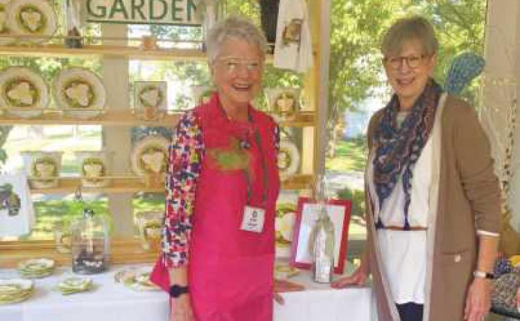 Country Garden Club members Kathy Attwood, at left, and Colleen McGoldrick in front of the club booth at the 2022 trunk show. Ms. McGoldrick is a co-chair of the upcoming show.