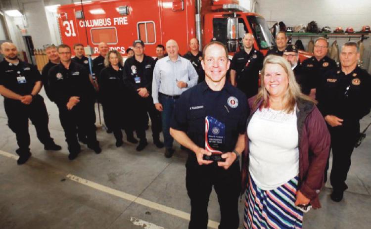 Holding his award is Firefighter Warnimont with his wife Terri at the crew at Station 31.