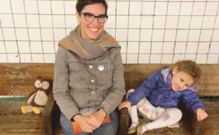 Amy Ballmer waits for a subway with her daughter, Lola.