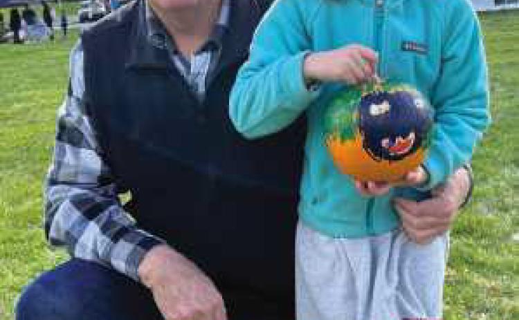 Lena Coulson, pictured with her grandfather and Perrysburg Rotarian Mark Weber, displays her painted pumpkin from last year’s event.