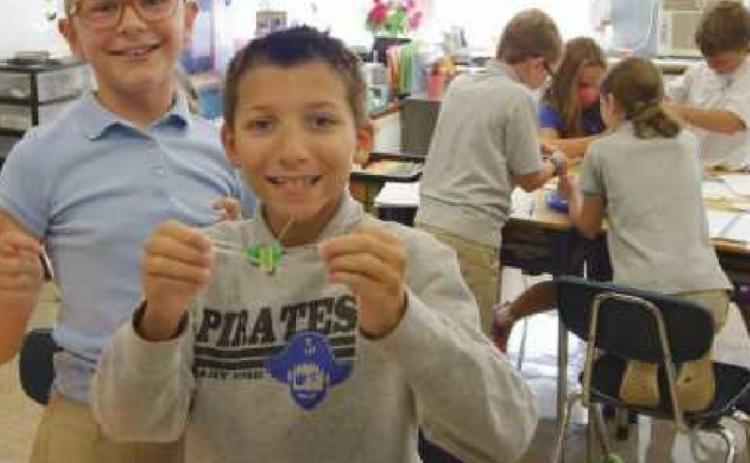 St. Rose fourth-graders Gracie Borgelt and Max Campbell show off their science lab work from the first week of the school year. It focused on the proper lab procedures, teamwork and problem-solving skills. Groups of students had to get Fred, a gummy worm, out of its capsized boat and into a gummy lifesaver without touching the worm with their hands.