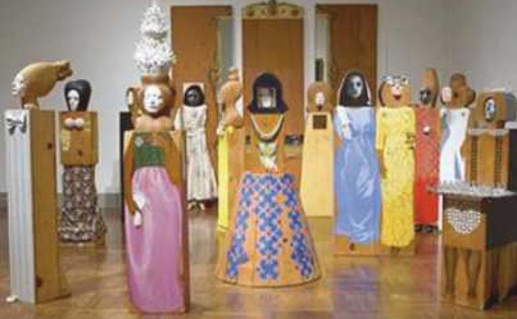 The exhibit includes “The Party,” an assemblage of 15 freestanding, life-size figures and three wall panels, with painted wood and carved wood, mirrors, plastic, television set, clothes, shoes, glasses and other accessories.