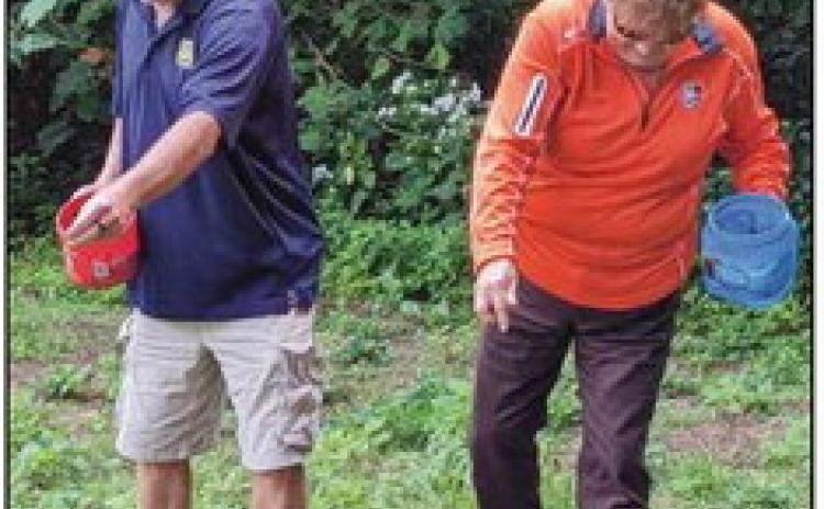Park Commissioners Bill Cameron and Sandy Wiechman spread seeds they collected on a section of ground at Bradner Preserve.