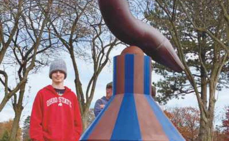 Artist Mike Sohikian donated the base of his sculpture, “Balance 1,” for a student design contest. Penta student Erik Baker, standing with the artwork, designed the winning entry.