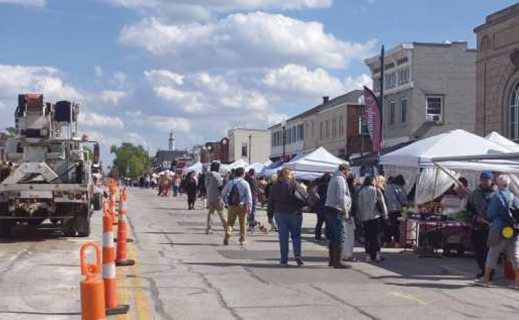 Construction equipment and vendor tents shared the road during the first Perrysburg Farmers Market of the year.