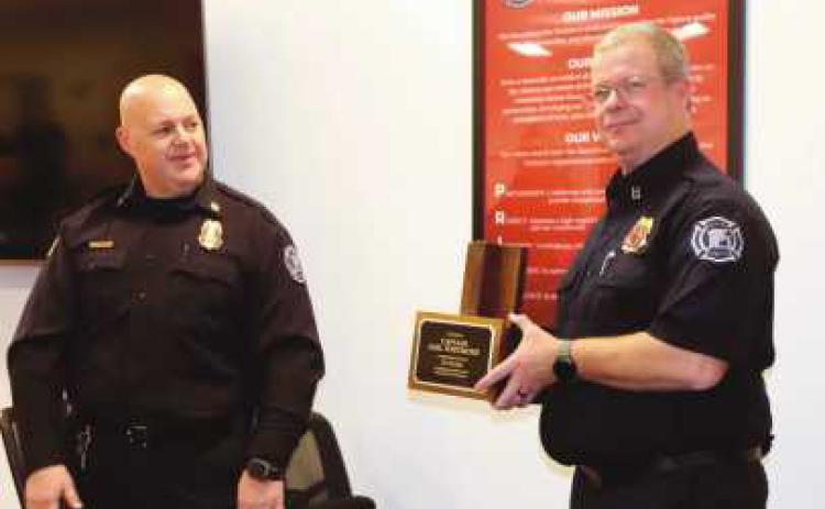 Chief McCullough, left, gives Whitmore, right, his engraved hat stand.
