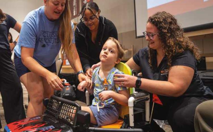 Cooper Mowen, center, was one of seven children invited to take part in the inaugural Bowling Green State University Doctor of Occupational Therapy program’s Go Baby Go event. (BGSU photo)