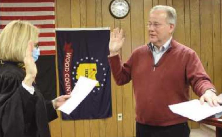 To open the January 5 meeting, Wood County Common Pleas Judge Molly Mack administered the oath of office to newly re-elected trustees Bob Mack, above, her husband, and to Gary Britten, below, whose wife Becky is holding the Bible.