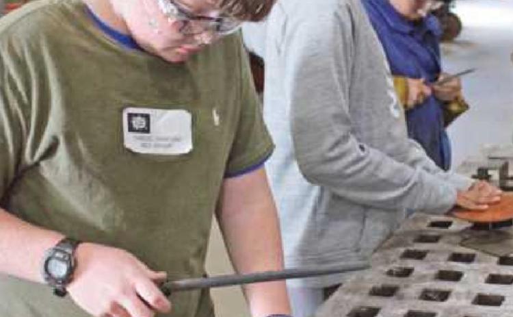 Above left Samuel Danford, foreground, and Sohan Gaddipati, Perrysburg Junior High School students, shave desktop organizers in preparation for welding. Kevin Orlowski,