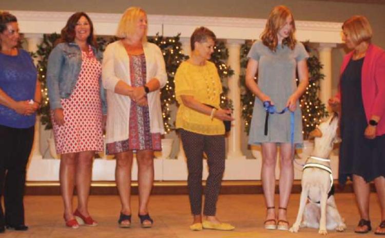Washington Local Schools superintendent Dr. Kadee Anstadt, fourth from left, receives Granger from Ability Center volunteers Mary Miller and Karen Bade. Also trained to be Granger’s new handlers are WLS staff, from left, Brittani Paszko, director of equity and inclusion; Lori Berryman, director of human resources; and Kristie Martin, assistant superintendent.